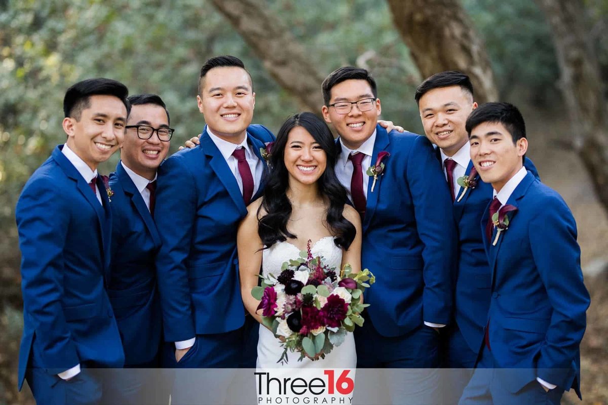 Bride surrounded by the Groomsmen in their blue suits
