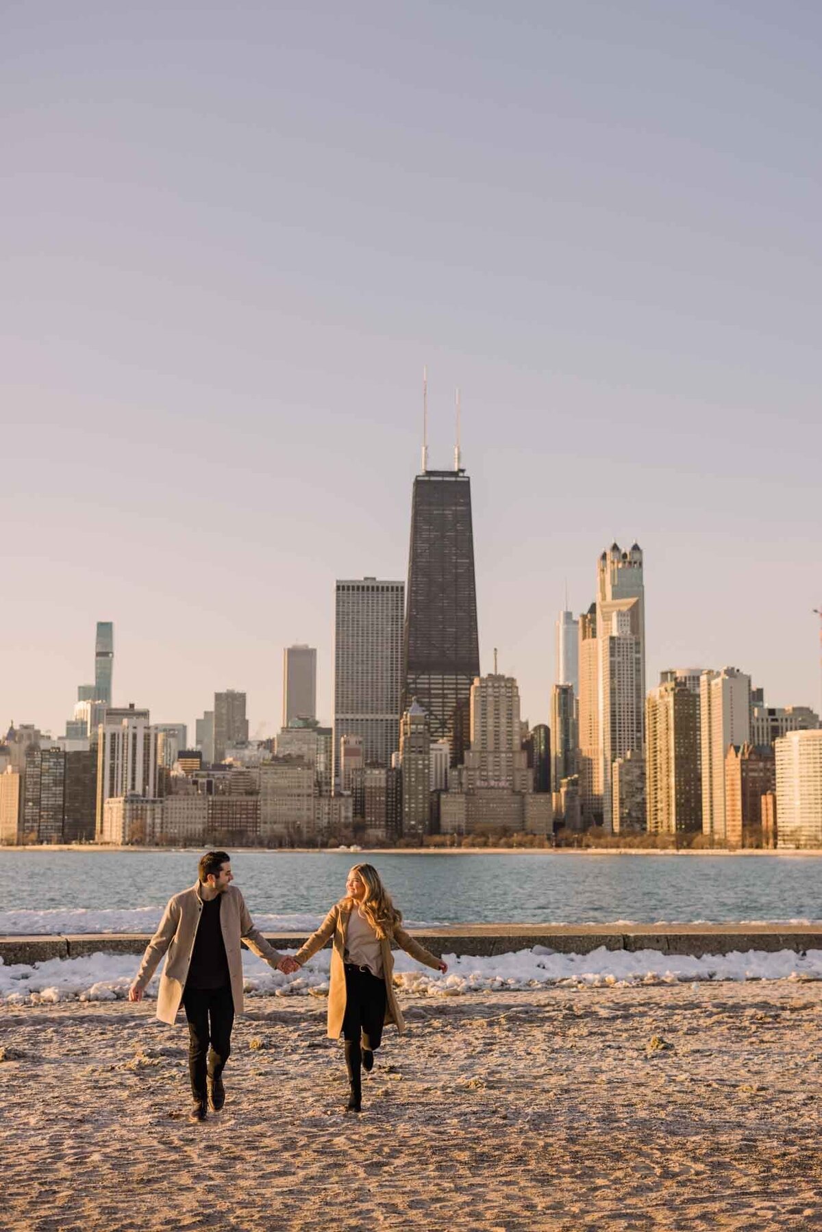 A couple run through the sand at North Avenue Beach in Chicago