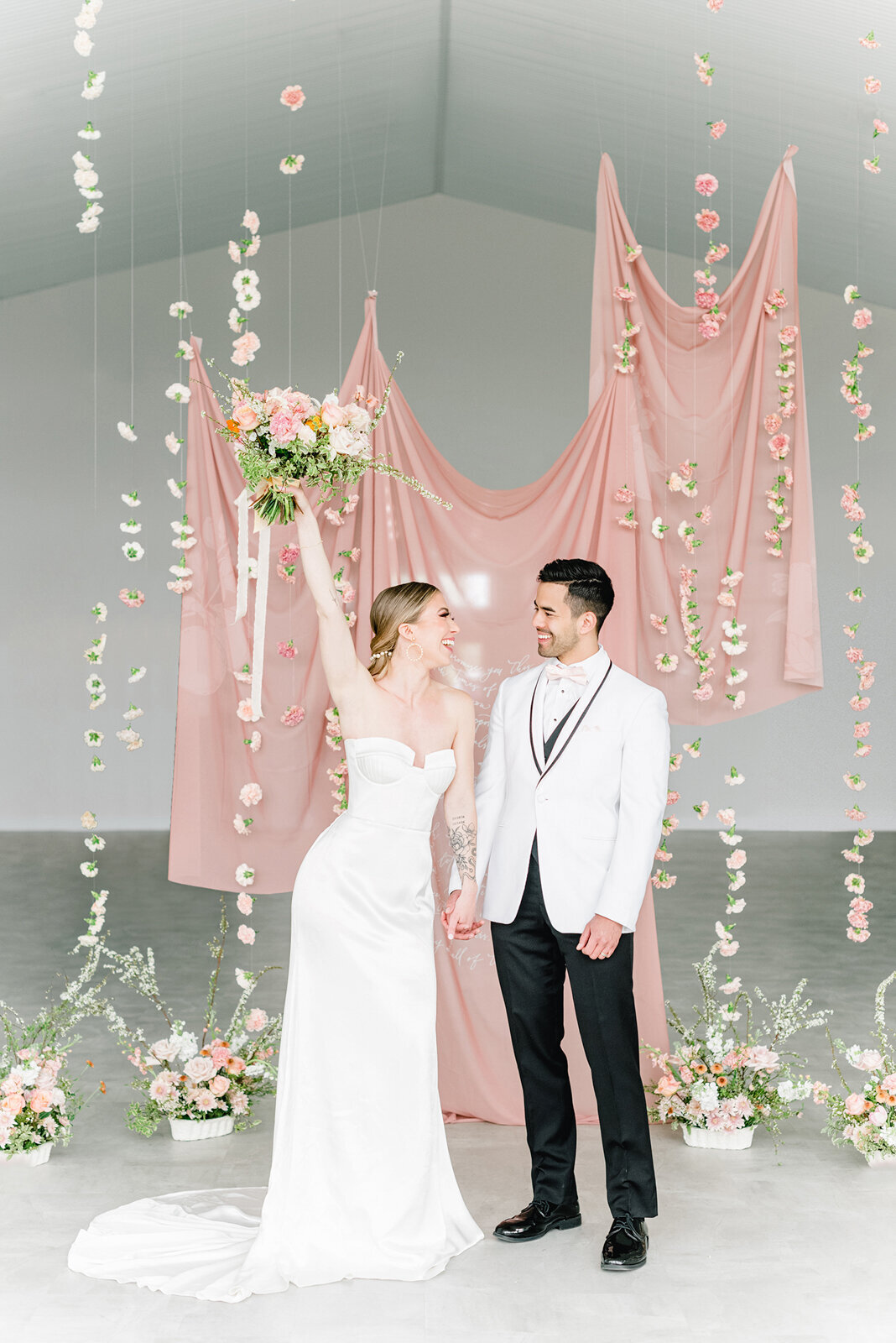 Gorgeous hanging pink florals at Tin Roof Event Centre, a modern wedding venue in Lacombe, Alberta, featured on the Brontë Bride Vendor Guide.
