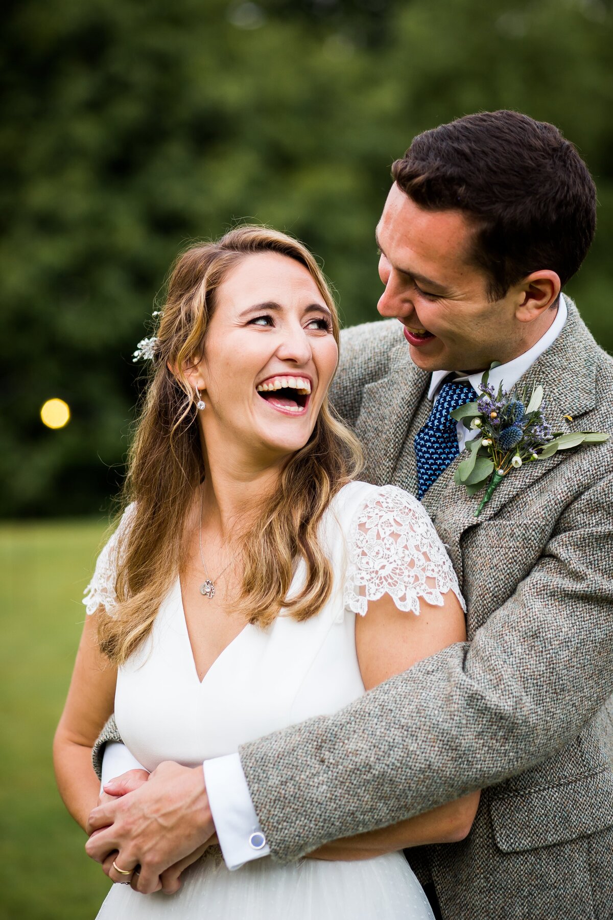 Bride and groom in embrace laughing on wedding day