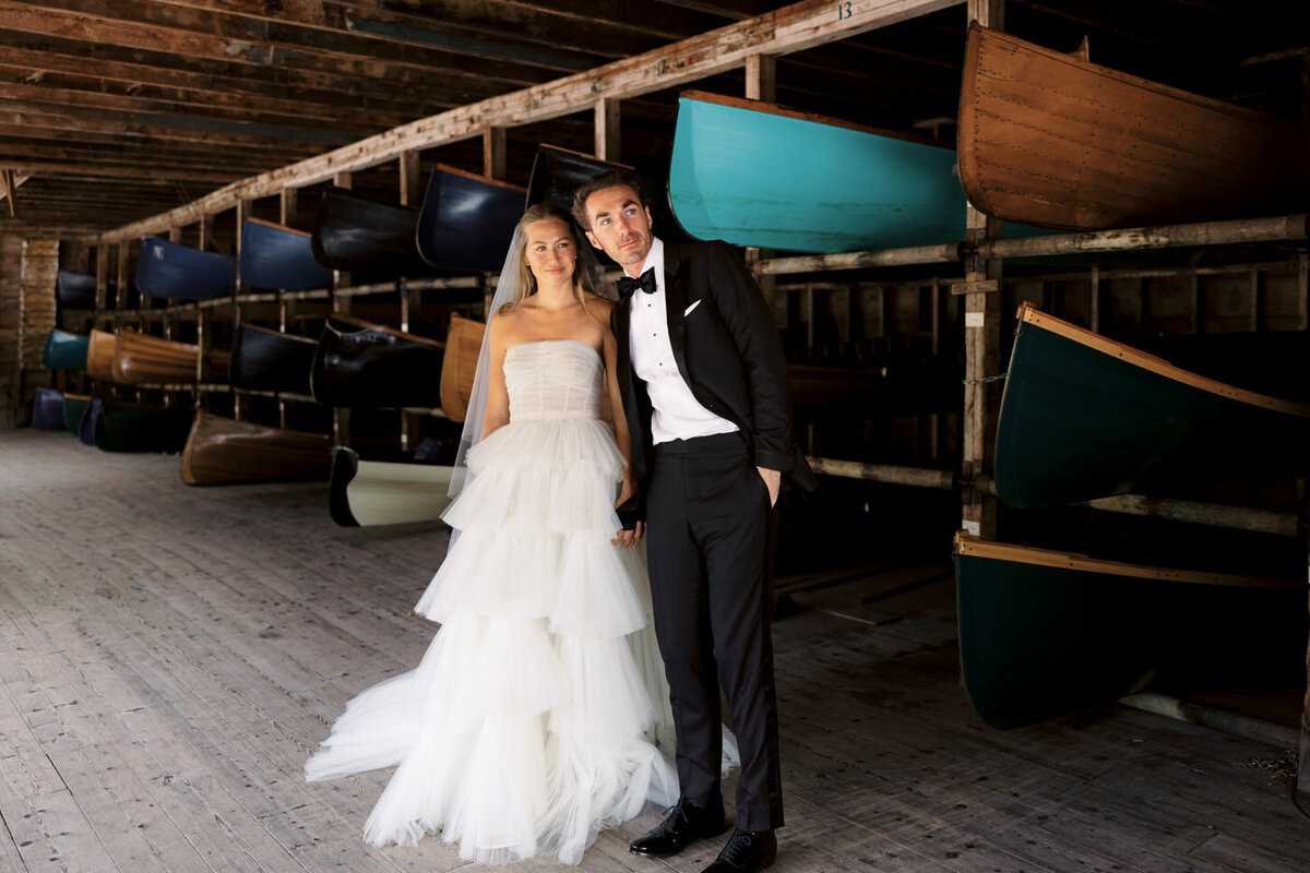 adirondack-mountain-wedding-12-bride-and-groom-posing-under-the-wooden-beams-of-a-classic-lodge-at-adirondack-mountain-wedding-jenny-fu-studio