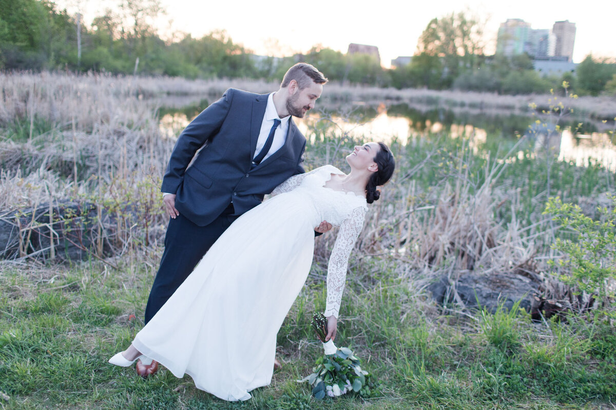 Immerse yourself in the enchantment of love by Dow's Lake as captured by Ottawa Wedding Photographer, Lauren Duffy. In this captivating moment, David gracefully dips Taylor, their laughter echoing against the backdrop of serene waters. Lauren Duffy Photography expertly preserves the essence of romance against the scenic beauty of Dow's Lake, ensuring every nuance of your love story is etched in time. Explore the magic of this iconic pose, skillfully framed to perfection, making your wedding memories truly timeless with the artistry of Ottawa's premier wedding photographer