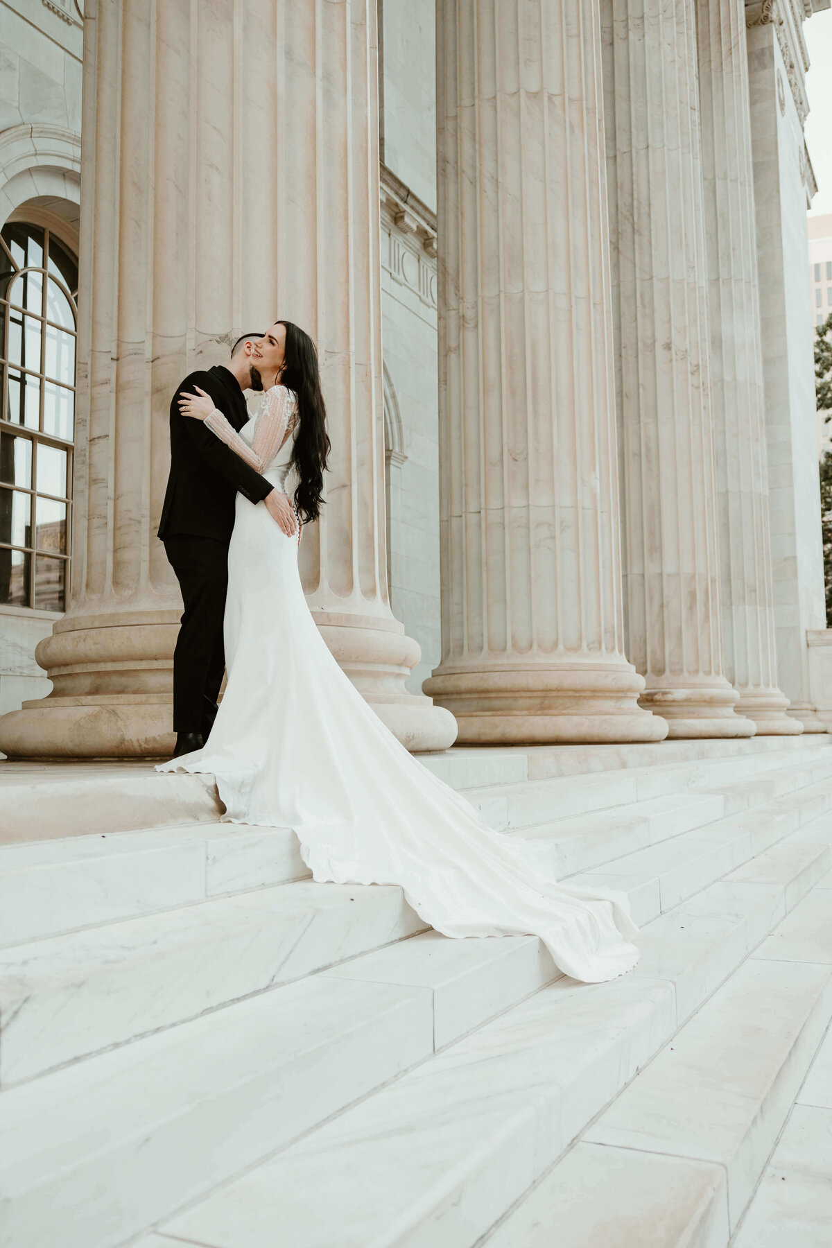 Bride and Groom Hugging on Marble Steps
