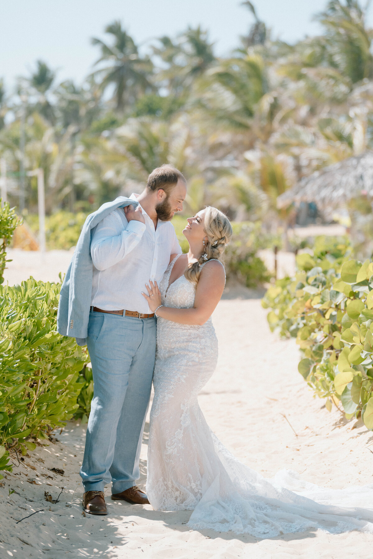 a bride and groom by palm trees in Punta Cana