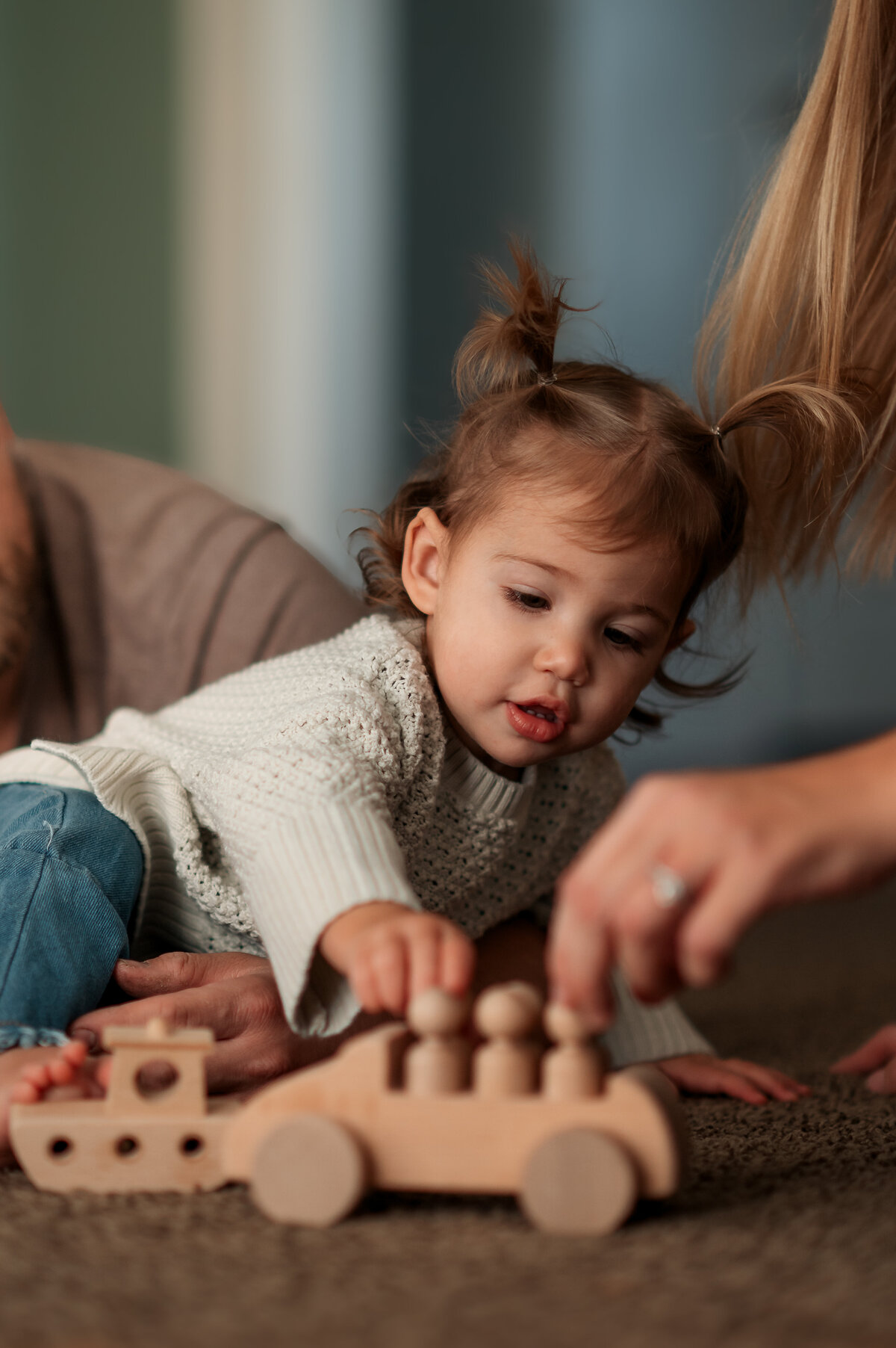 Close-up of a toddler playing with a wooden toy during a lifestyle Story of Home session.