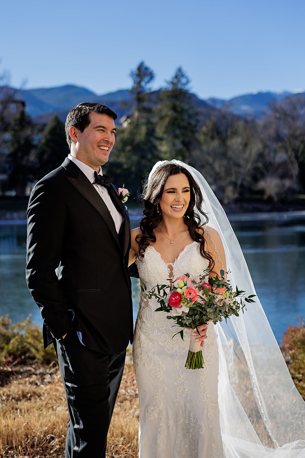 Bride and groom in front of a lake at the Broadmoor Hotel.