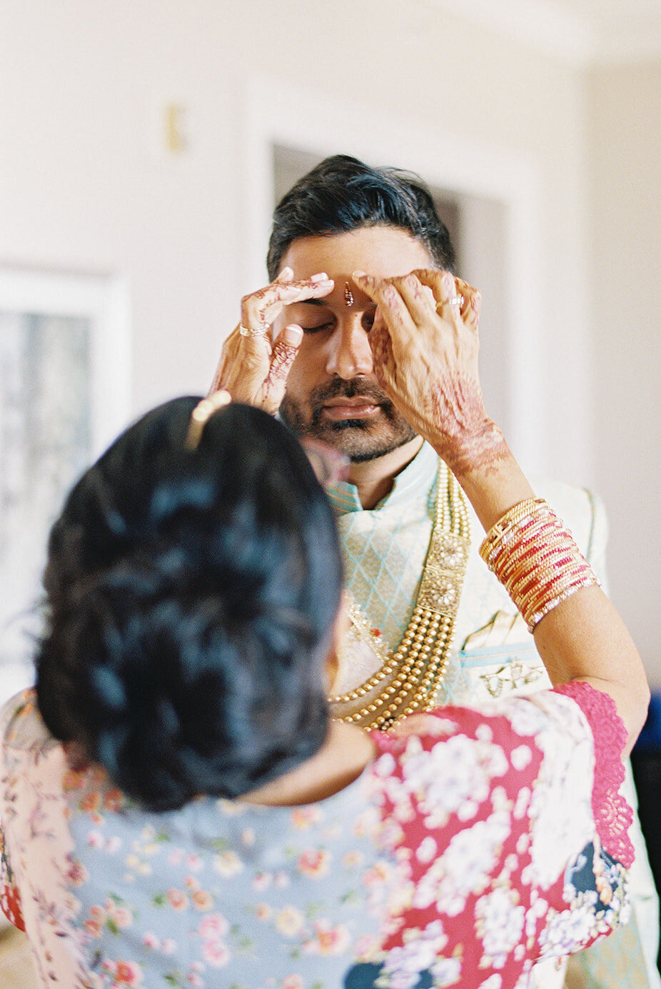 Mother of the groom getting groom ready at a destination wedding