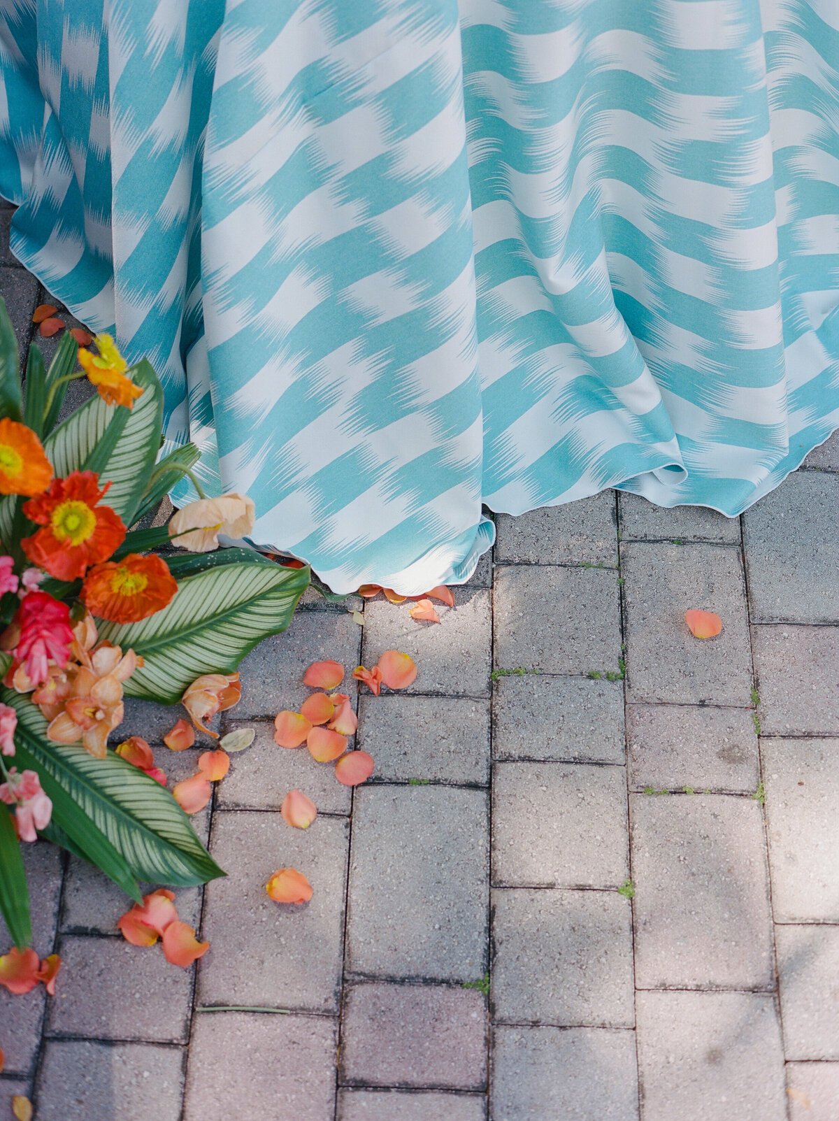 The florals and the edge of the tablecloth on the ground.