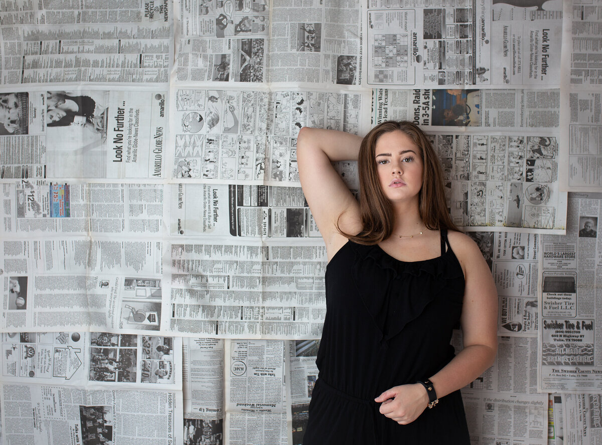 Creative studio senior session with newspapers