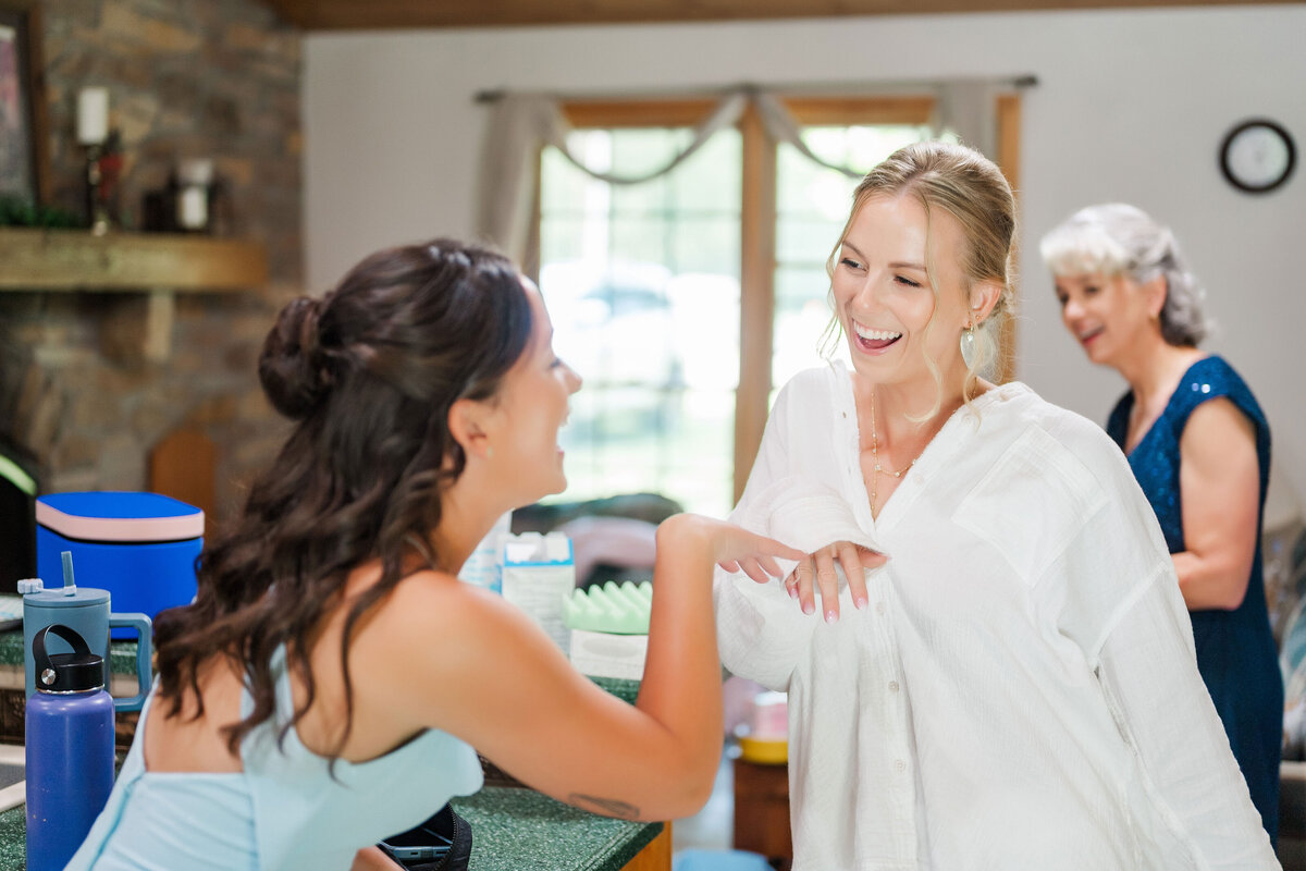 candid photo of the bride joking with her sister in law on her wedding morning