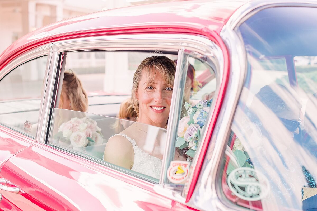 bride smiles through vintage car window at Disney Wedding Pavilion