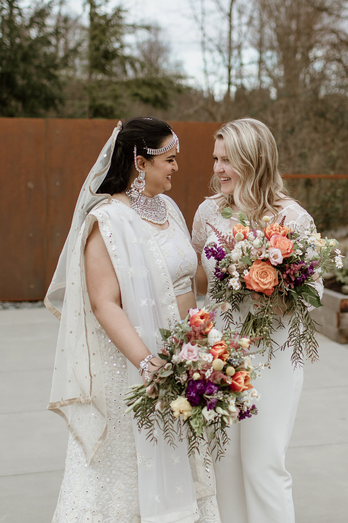 A sweet smiling moment of an LGBTQ+ couple, Indian Bride at Novelty Hill-Januik Winery in Woodinville Washington. Captured by Fort Worth wedding photographer, Megan Christine Studio