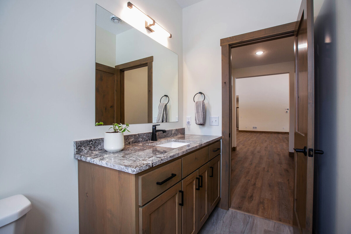 Custom bathroom with dark wood and modern accents in Elk River custom home