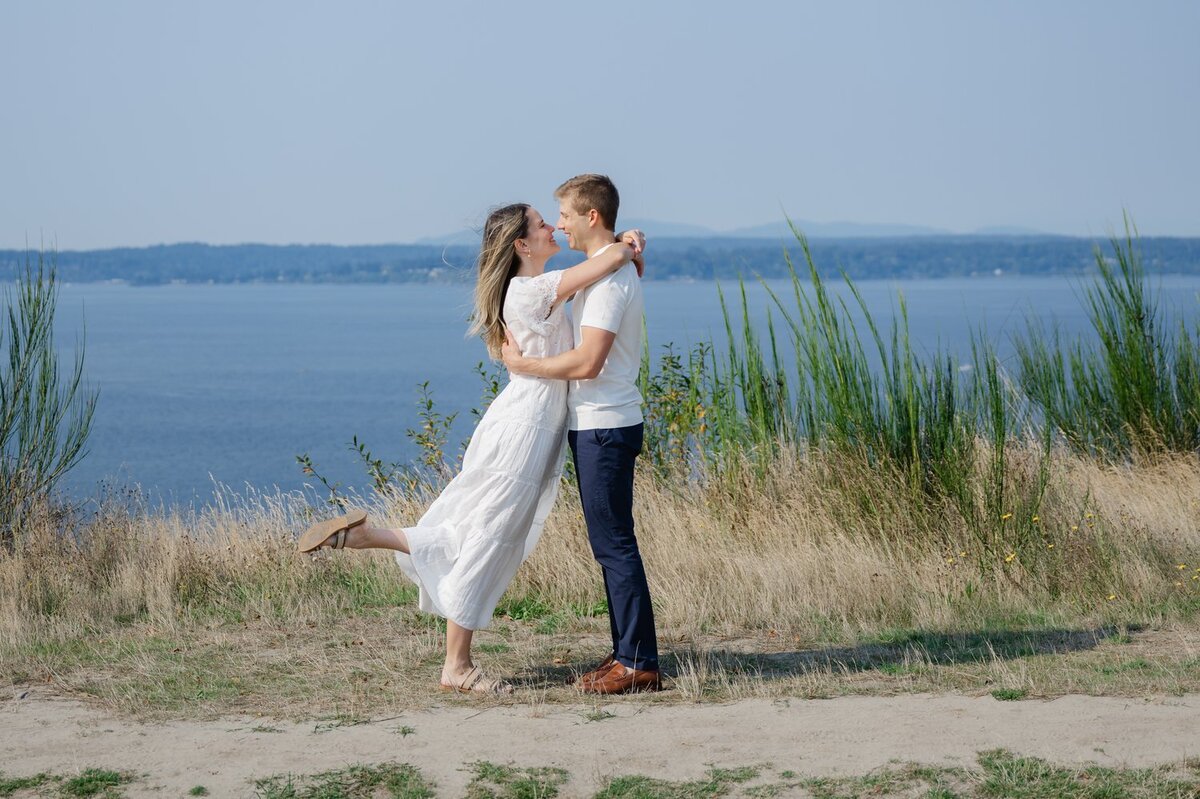 couple hugging on bluff in seattle overlooking puget sound