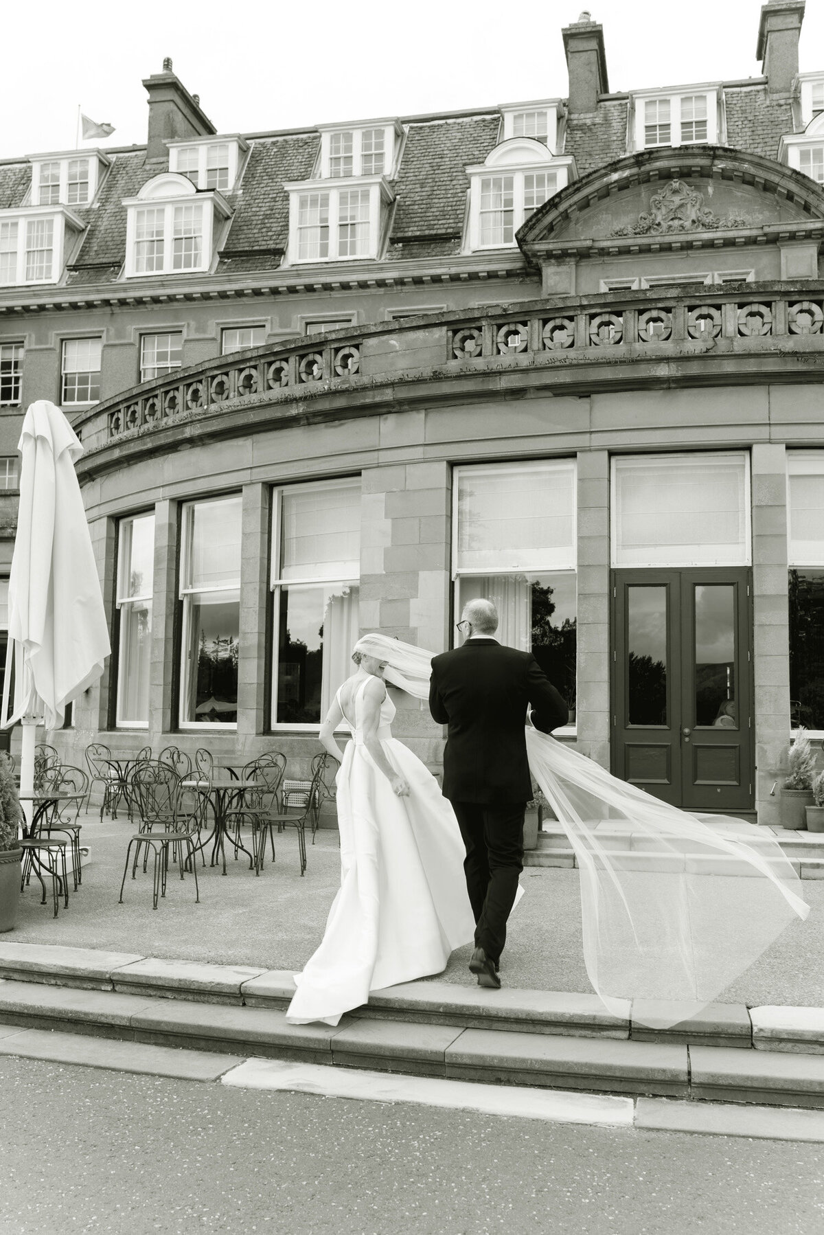 Windswept romance as the veil takes flight during editorial wedding photography in the grounds of Gleneagles Hotel. Image by luxury wedding photographer Scotland, Jill Cherry Porter.