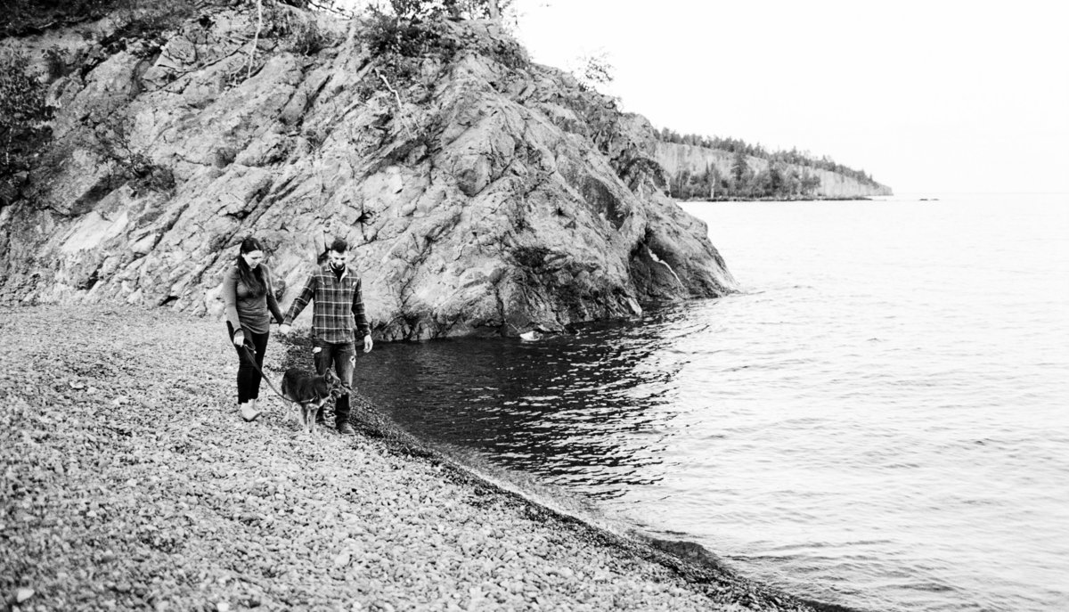 coupld walks along the rock shoreline of lake superior