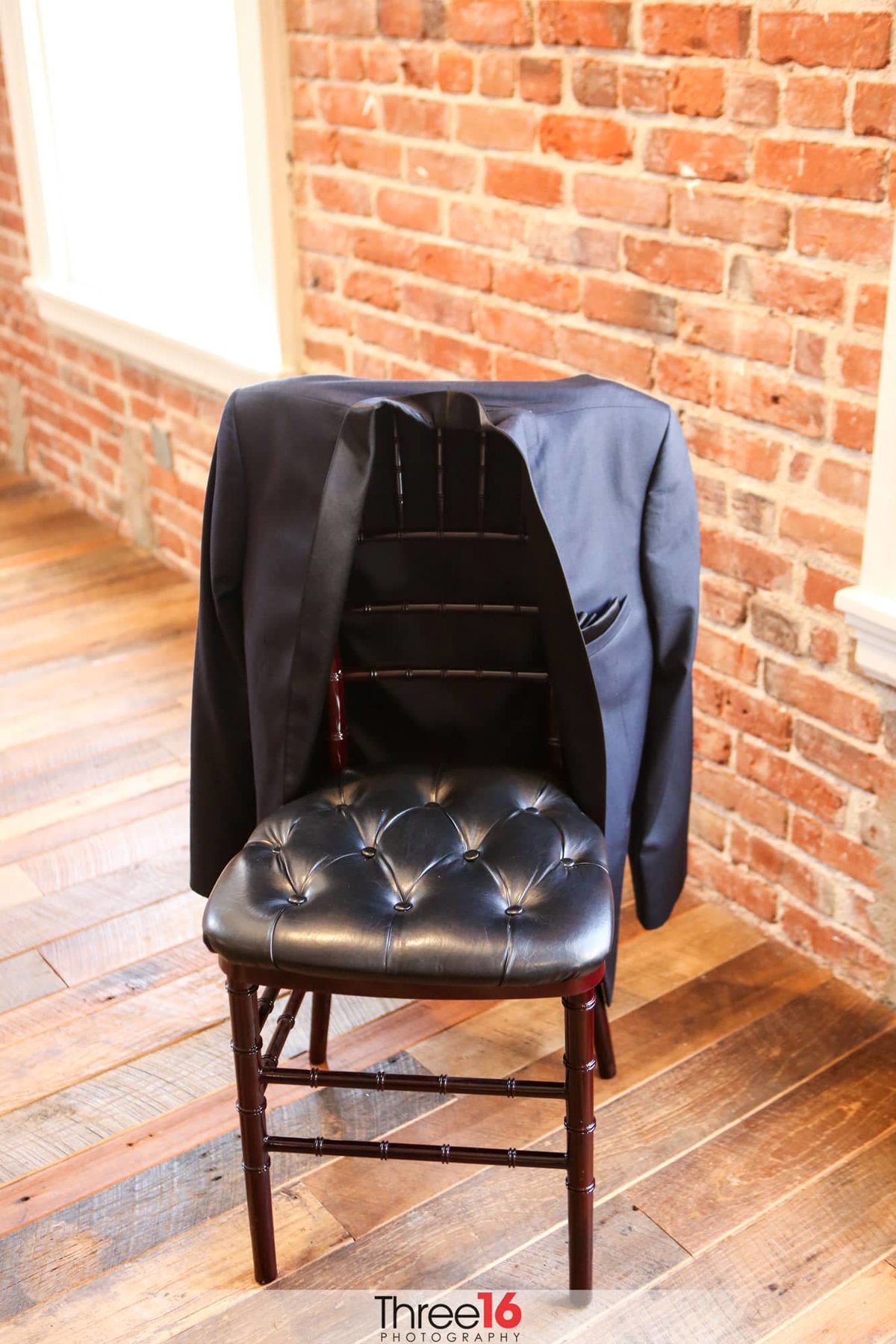 Groom's coat sitting on the back of a chair