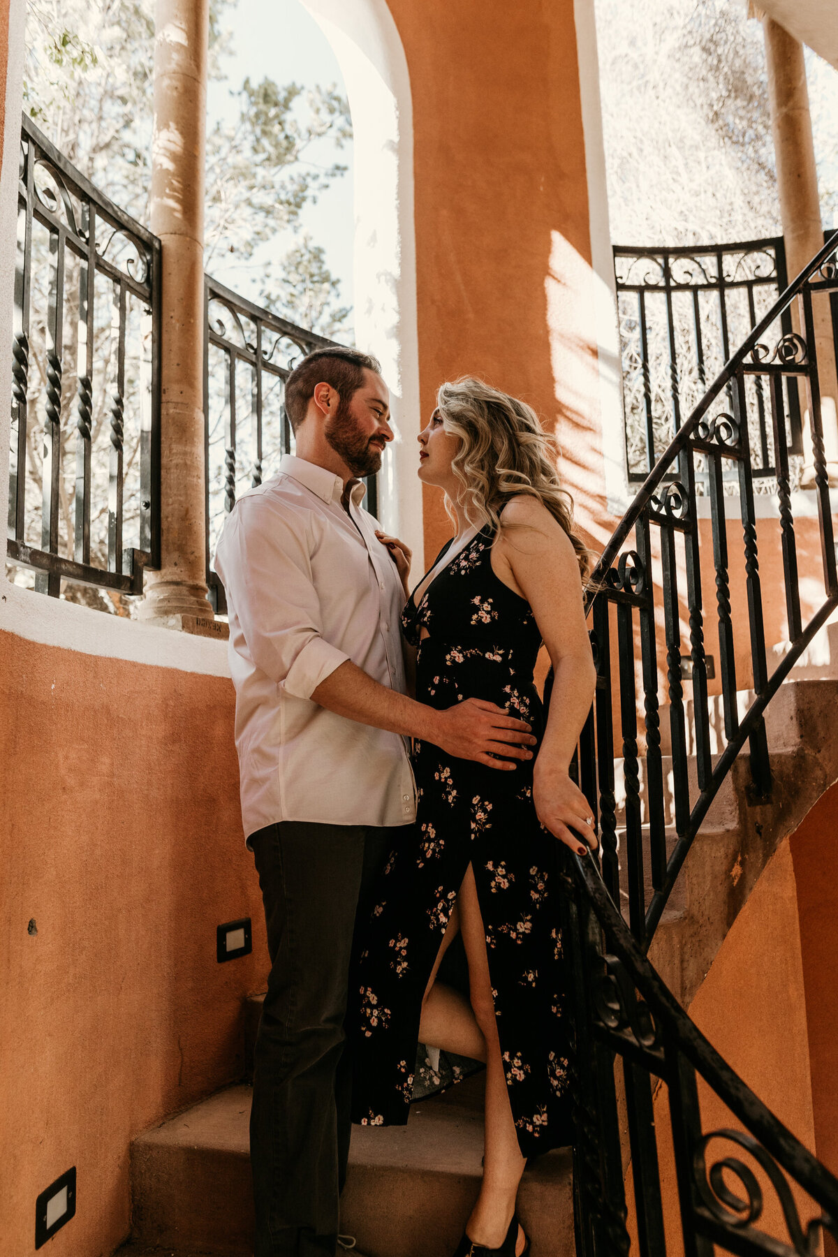 engaged couple standing on a staircase