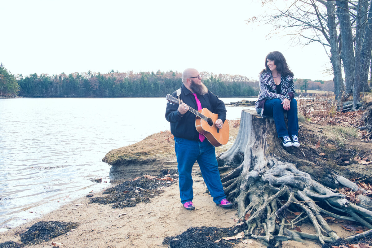 engaged couple on a beach playing music