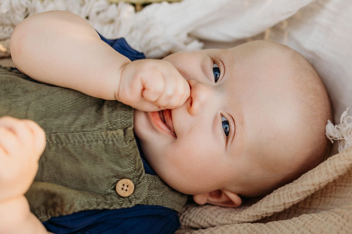 Close up of baby boy  face smiling at Kyla, an Eau Claire  family photographer