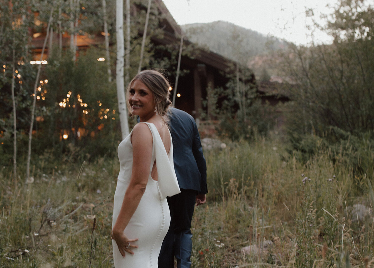 Alana and Ryan walking through the field of grass and flowers