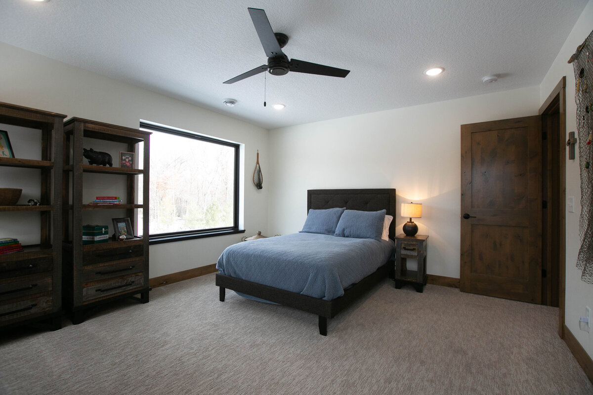 Custom bedroom with dark wood accents and neutral tones in Elk River home by Cornerstone Custom Builds