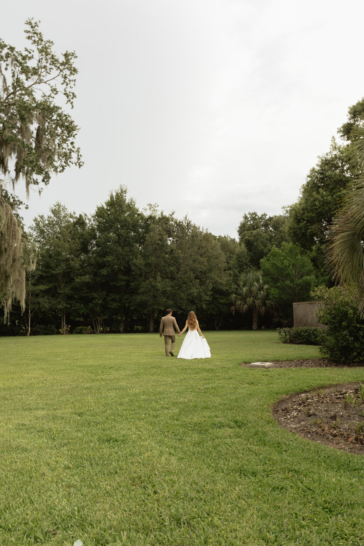 Romantic backyard wedding at The Palm Mansion in Umatilla, Florida with lush palm trees and floral arch