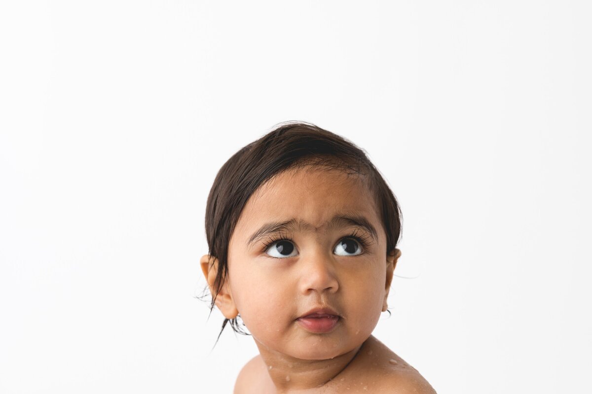 Baby wearing a big smile hat at a first birthday photoshoot by Hobart Photographer Lauren Vanier