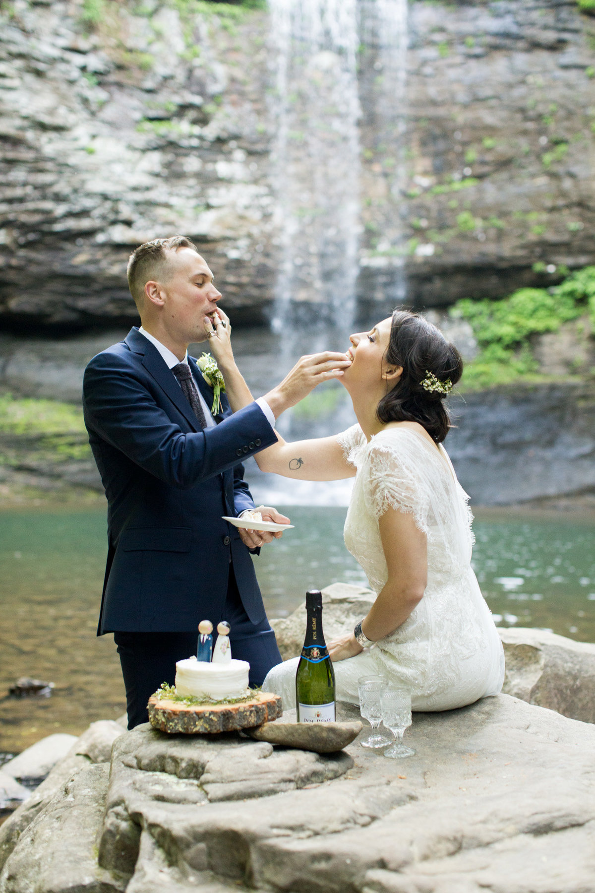 Cake cutting traditions by a waterfall by destination elopement photographer Rebecca Cerasani