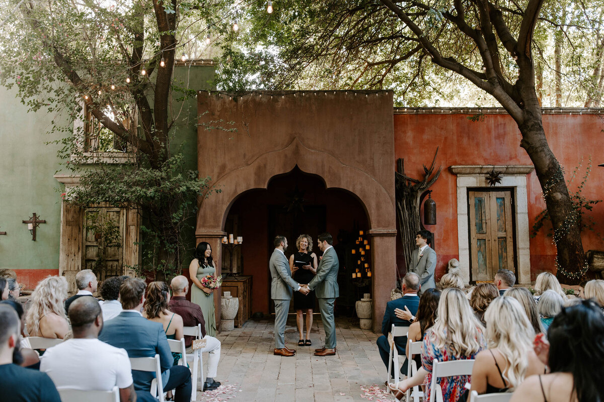 Two people hold hands exchanging vows at their ceremony in Phoenix.