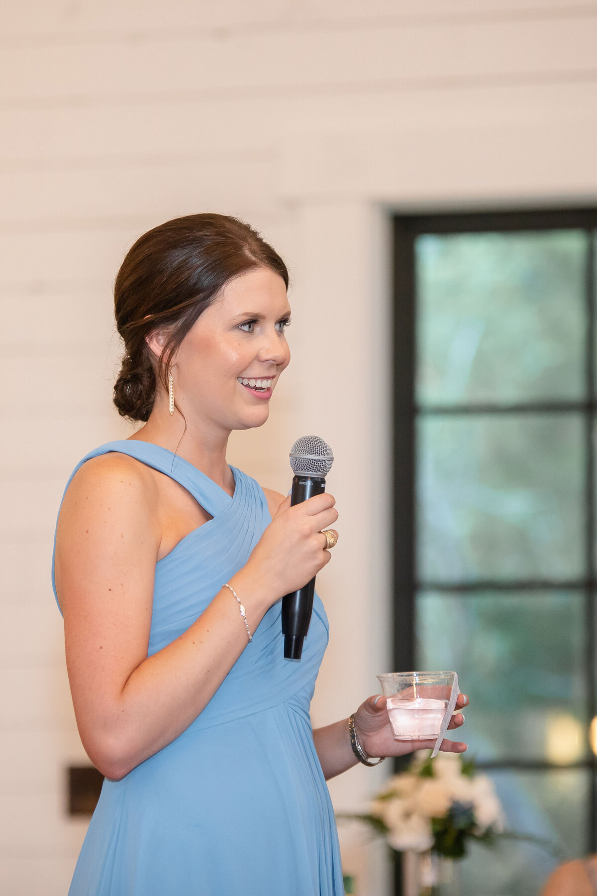 maid of honor in blue dress gives speech at Morgan Creek Barn in Dripping Springs Texas