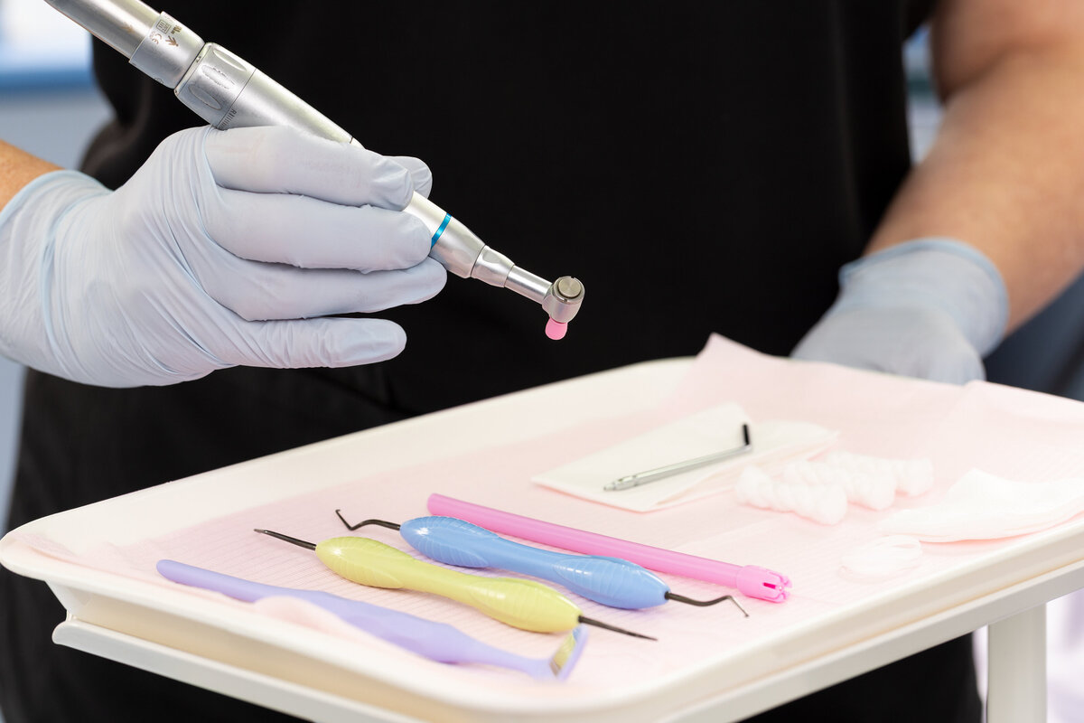 Dentist picking up tools from cart