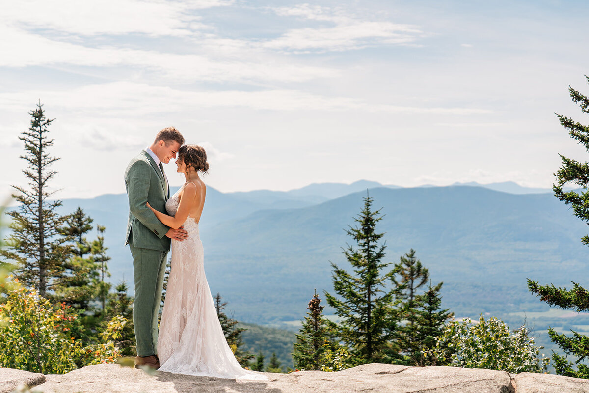 A couple stand together on a mountain in Maine during their Maine wedding. Taken by their Maine Wedding photographer, Jenna Richmond.
