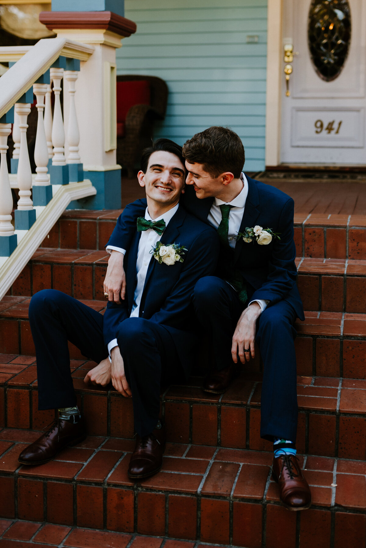 grooms sitting on steps smiling