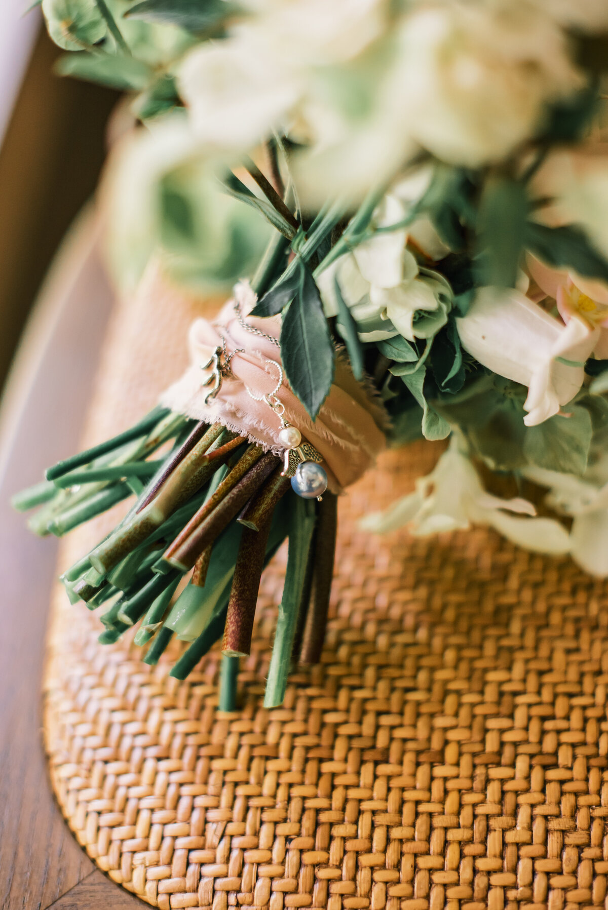 Close-up of bridal bouquet wrapped with ribbon and sentimental charm, photographed at Old Edwards Inn wedding in Highlands, North Carolina.