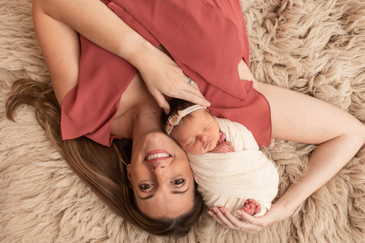 Mom smiling at camera, holding newborn baby girl |Sharon Leger Photography || Canton, CT || Family & Newborn Photographer