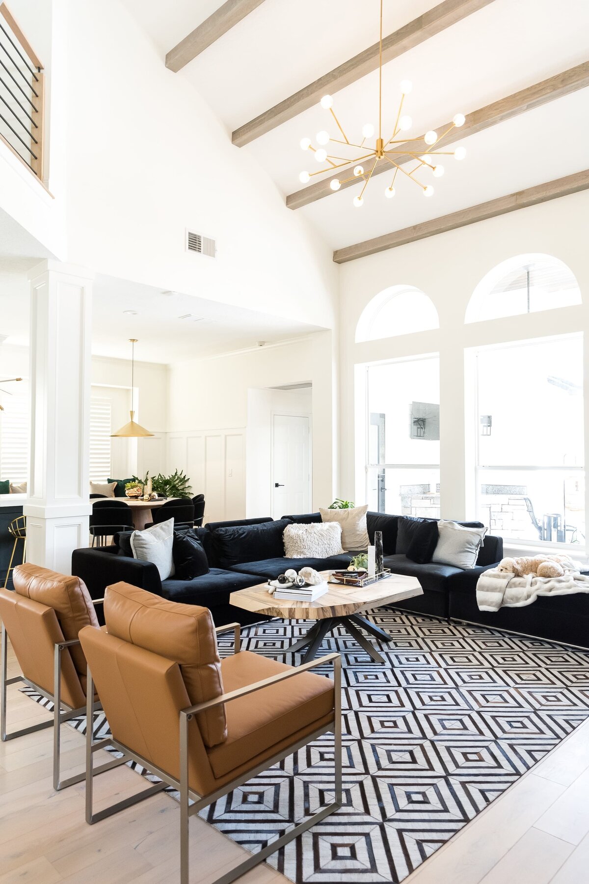 dewine design orlando interior designer modern lakehouse living room with black sofa and leather chairs and vaulted ceilings