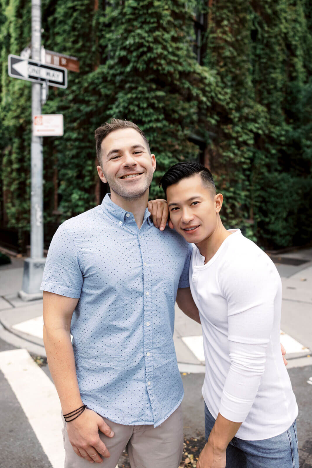 The engaged couple is happily standing in the corner of an ivy-covered building at West Village, NYC. Image by Jenny Fu Studio