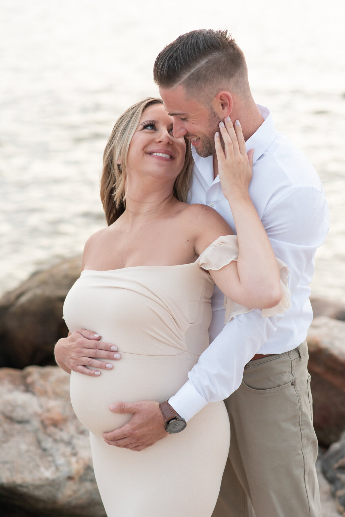 Pregnant couple embracing on the beach