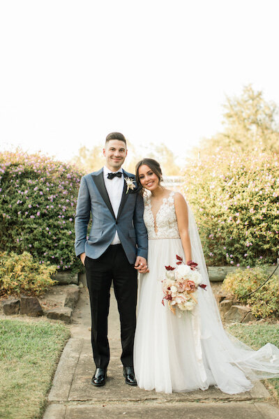 bride and groom standing together with bouquet