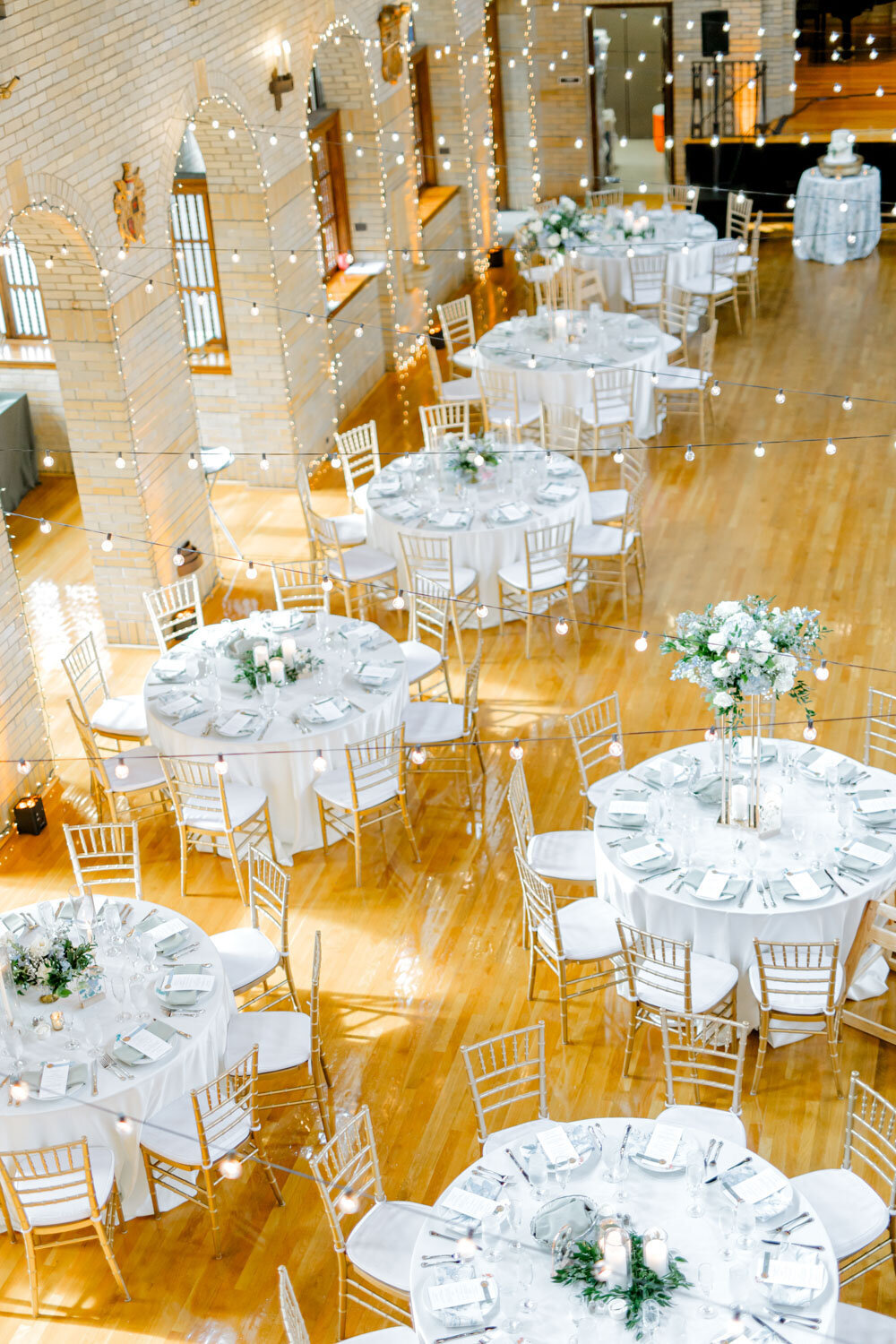 Overhead view of round tables with gold chairs and white linens