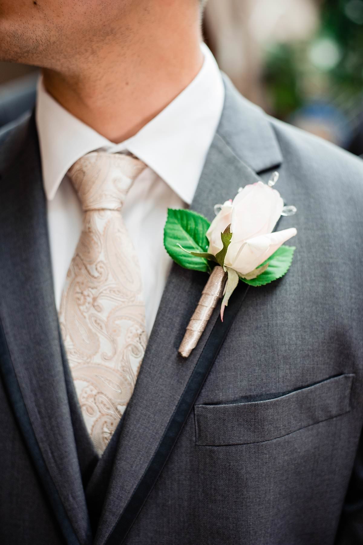 White rose boutonniere and paisley ivory tie