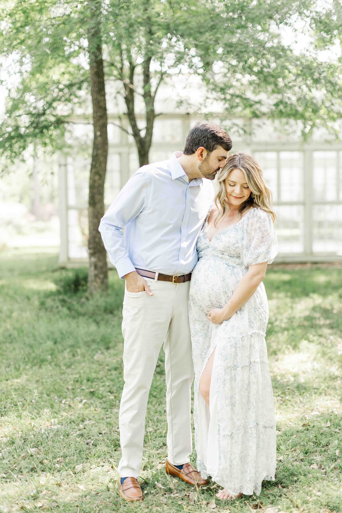 dad kisses mom on the forhead for hosuton maternity portrait