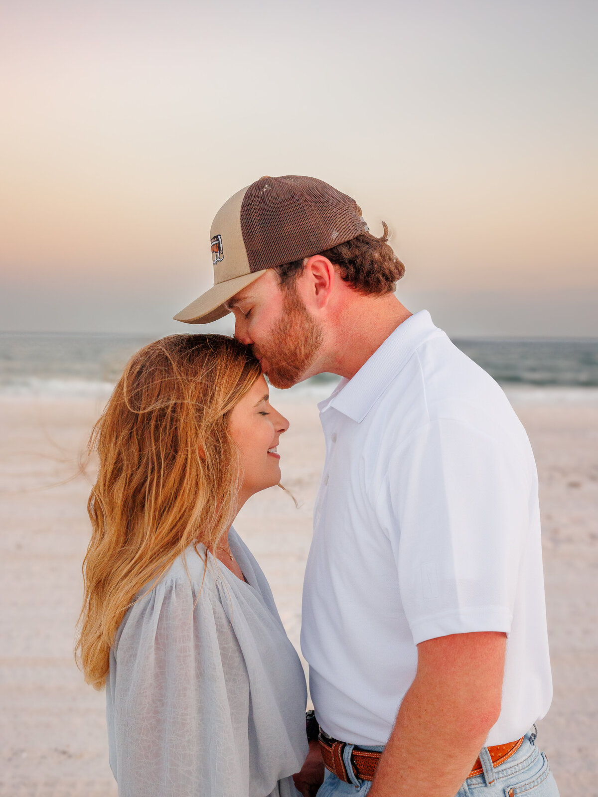 Guys leaning into girl for a forehead kiss while girl closes her eyes