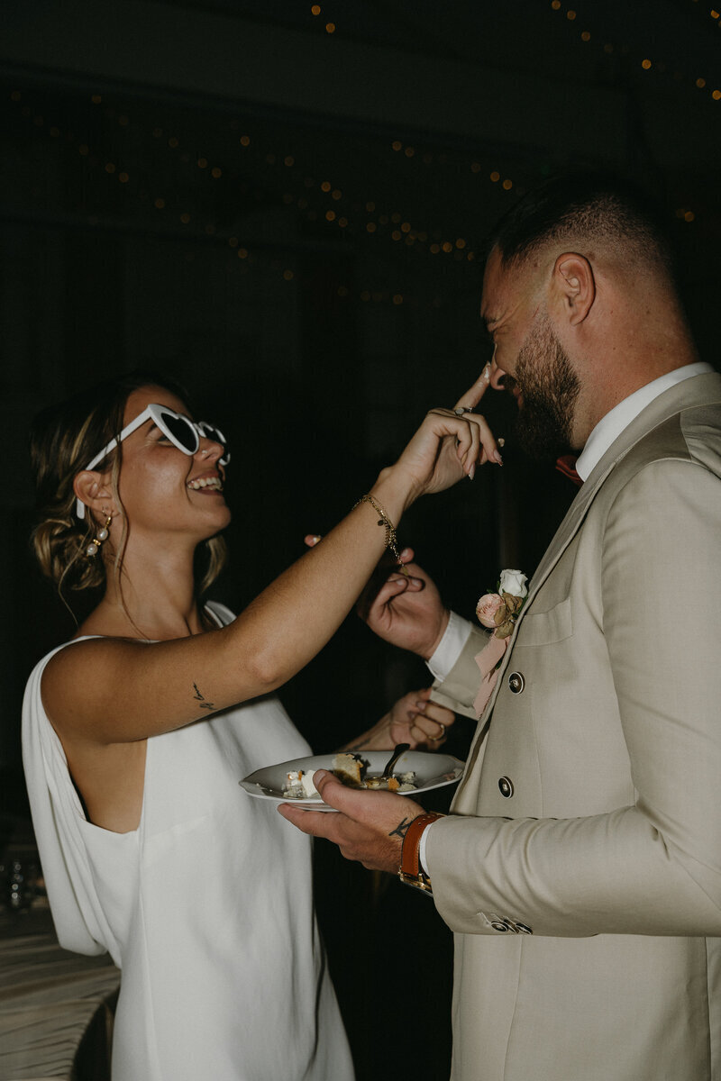 Mariée mettant du gateau sur le nez de son mari. Projet organisé par Nos moments ensemble, organisatrice de mariages Vendée et Loire Atlantique.