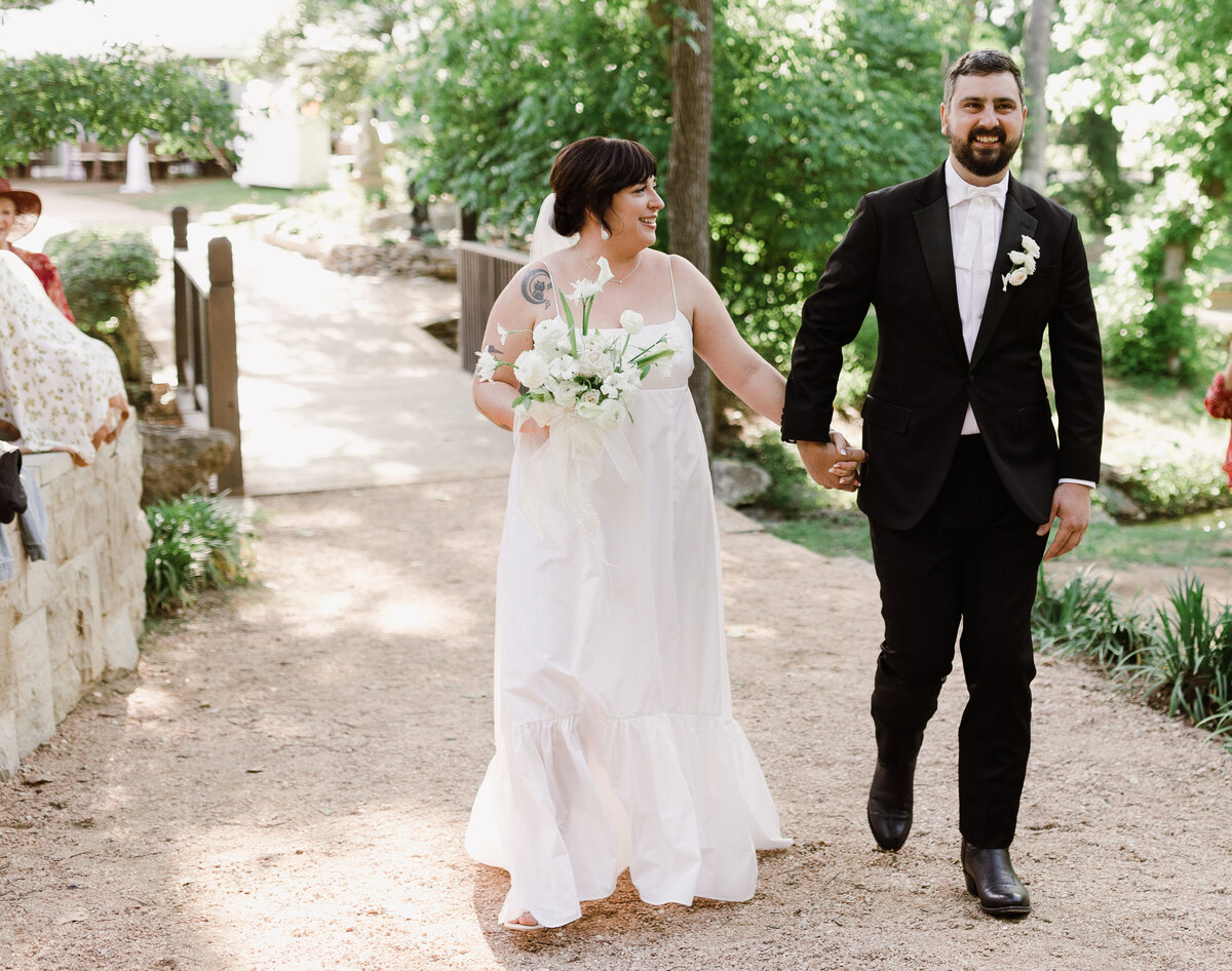 Bride and groom walking along hand in hand at Umlauf Sculpture Garden Wedding, Austin