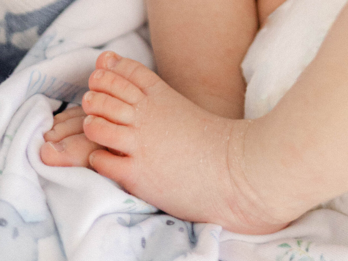 Close-up shot of newborn baby toes snuggled up in a blanket.