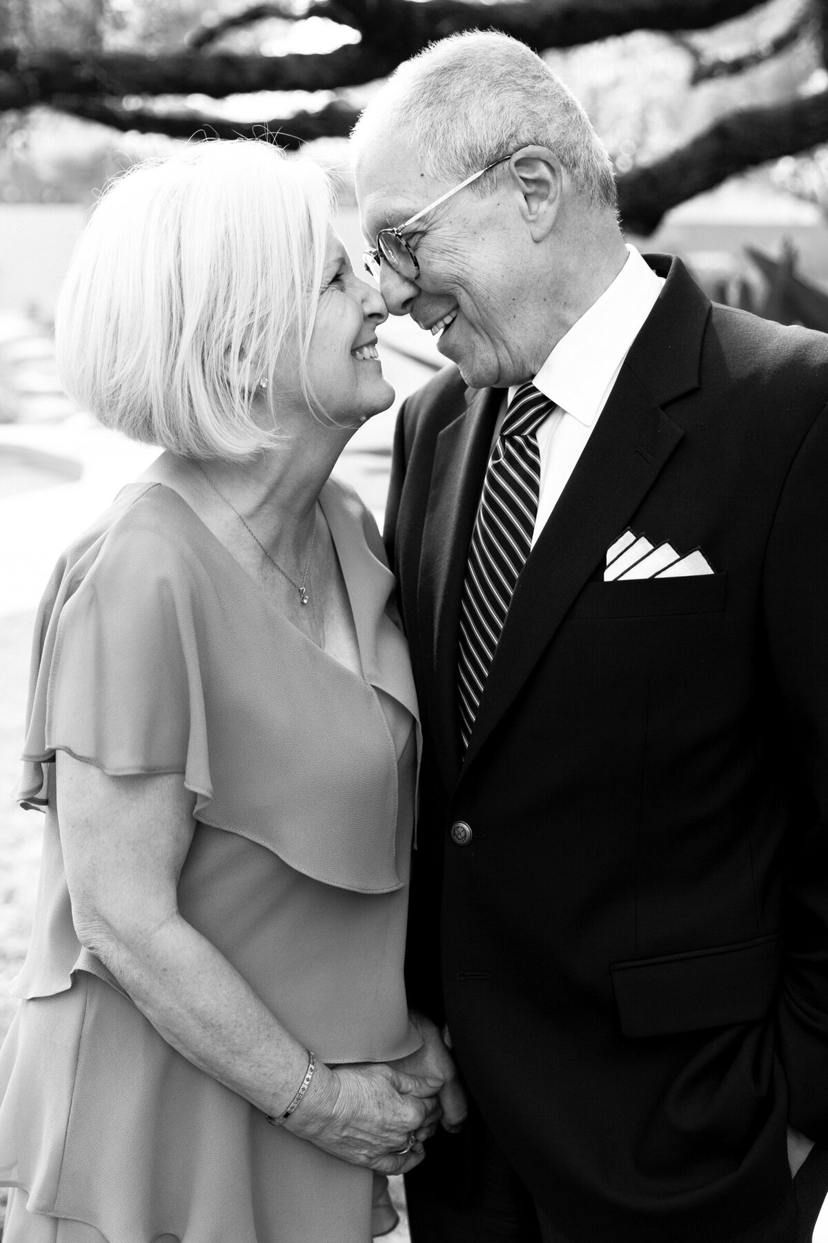 older couple posing nose to nose for wedding photo