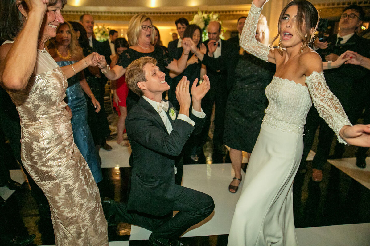 A bride and groom are dancing at their wedding reception