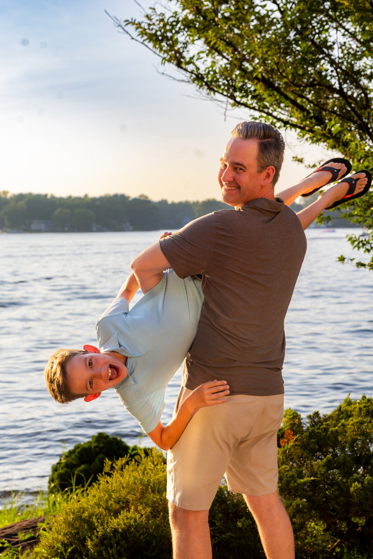 Father swinging his son playfully by the ocean, captured by Capture Joy Photography, Northern Virginia family photographer.
